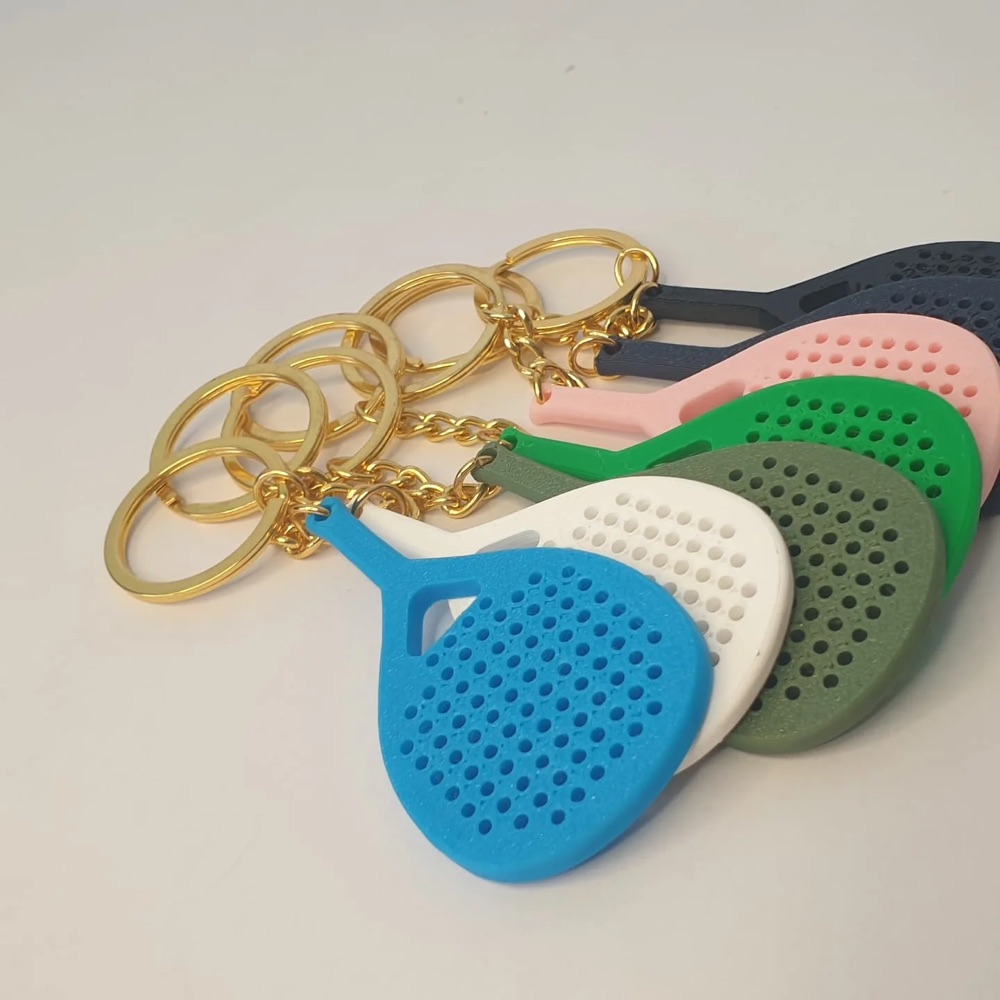 Padel racket keychains in blue, white, pink and green